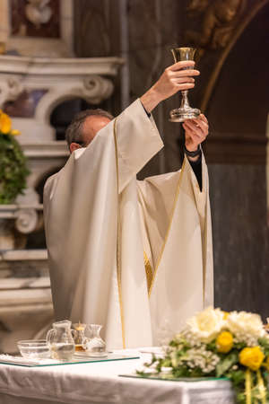 The elevation of the Goblet with the sacramental wine during the Catholic Liturgy of the Eucharistの写真素材