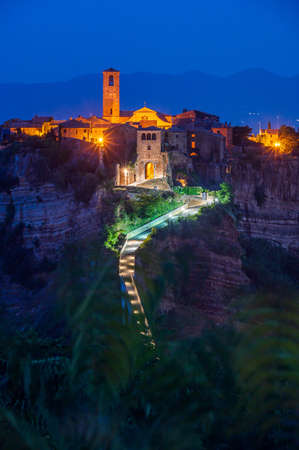 The ancient village of Civita di Bagnoregio, also called the diying city, in the region of Tuscia, Italy, at the blue hourの写真素材