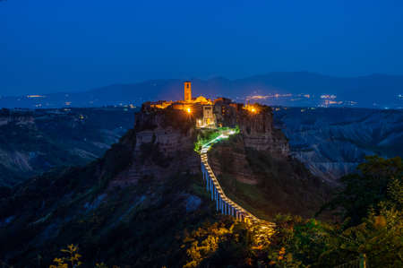 The ancient village of Civita di Bagnoregio, also called the diying city, in the region of Tuscia, Italy, at the blue hourの写真素材