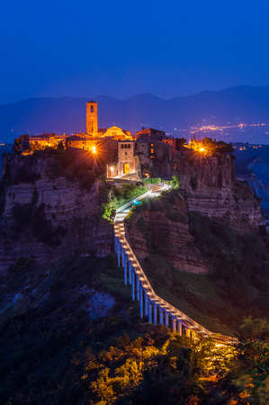 The ancient village of Civita di Bagnoregio, also called the diying city, in the region of Tuscia, Italy, at the blue hourの写真素材