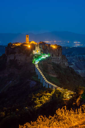 The ancient village of Civita di Bagnoregio, also called the diying city, in the region of Tuscia, Italy, at the blue hourの写真素材