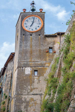 Clock Tower of a palace in the old town of Capodimonte, ancient village on the Bolsena Lake, Lazio, Italyの写真素材