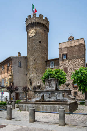 Clock tower at the gate, entering the old town of Bagnaia, in Tusciaの写真素材