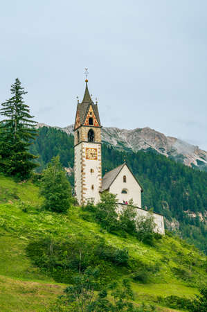 The ancient church of Saint Barbara on a scenic position in La Val, Val Badia, in the heart of Dolomitesの写真素材