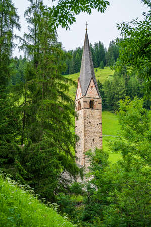 Clock Tower of the ancient church of Saint Genesio in La Val, Val Badia, in the heart of Dolomitesの写真素材