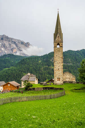 Clock Tower of the ancient church of Saint Genesio in La Val, Val Badia, in the heart of Dolomitesの写真素材