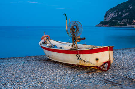 Fishing Boat on the beach of Noli, on the Italian Riviera, at the duskの写真素材