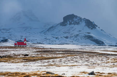 White church with red roof in the snowy landscape of Hellisandur, Icelandの写真素材