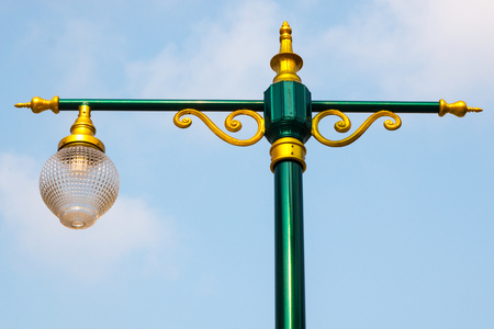 colorful old street lamp post . outdoor light element with beautiful sky background . electricity vintage building object . Lamppost with white glass lampの写真素材