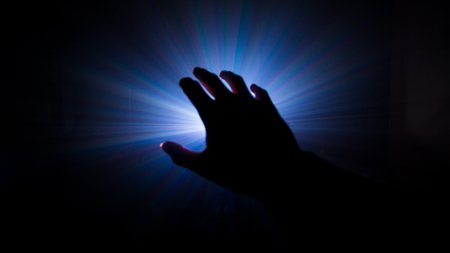 A dark hand human for help . fantasy beautiful light at background . silhouette mystery retro style .の写真素材