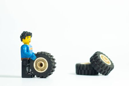Bangkok Thailand -Aug3,2018: Lego toy mini figures , dirty repairman change tire wheels car at work shop on white background . studio shot picture job concept . plastic fun collection for child .のeditorial素材