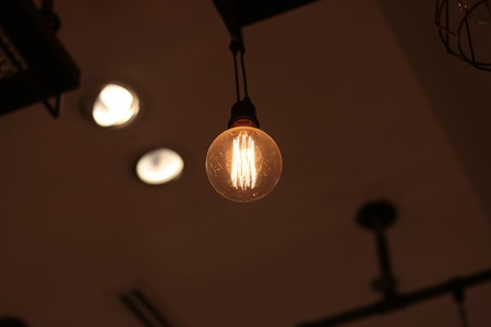 A electric lamp lighting . modern and vintage style , interior ceiling hanging light bulb decorate at roomの写真素材