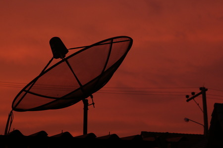 red sky at night and dish satellite on the roof