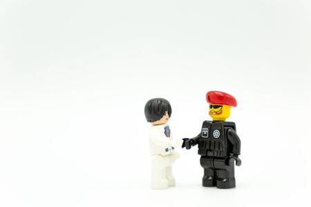 Bangkok Thailand -May, 2019: lego toy business man holding hand with soldier on white background .のeditorial素材