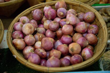 heap of onions vegetable in market .