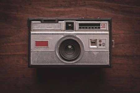 Old and worn photo camera from the 60s on rustic wooden tableのeditorial素材
