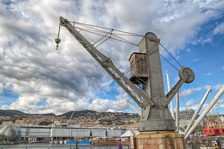 Under the cloudy sky View of an old industrial crane in the ancient port of Genoa (GEnova).のeditorial素材