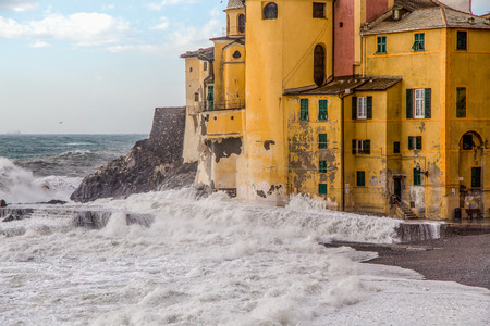 Old church with rough sea and big waves in Camogli, Genoa, (Genova), Italyの写真素材