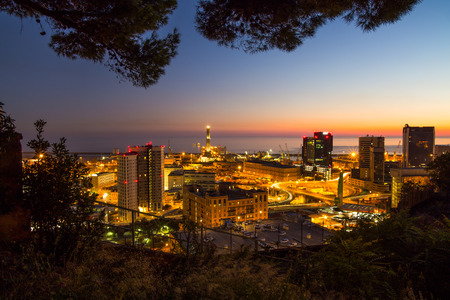 Industrial area near the port with commercial skyscrapers at night, Genoa (Genova), Italy.のeditorial素材