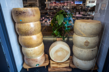 GENOA, ITALY, APRIL 5, 2018 - Stacked Parmigiano Reggiano forms, the most famous Italian cheese on sale in a shop.のeditorial素材