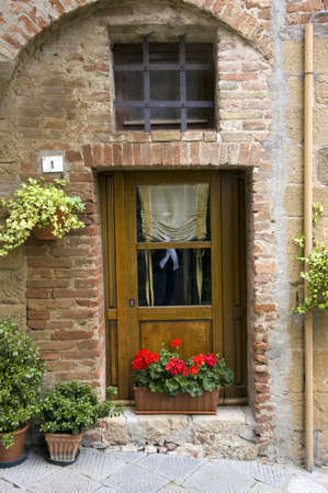 Old wooden door with potted flowers. Italian style. Tuscanyの写真素材