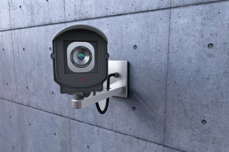 security camera looking at you on concrete wallの写真素材