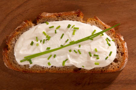 Dark bred with cream cheese on wooden boardの写真素材