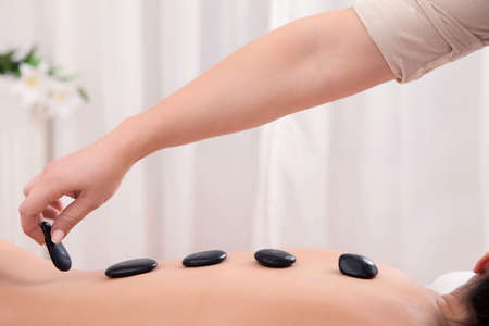 Hot stone theraphy hands laying down stones