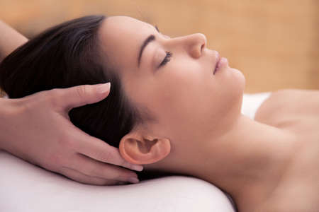 Acupuncture treatment in the head of an asian womanの写真素材