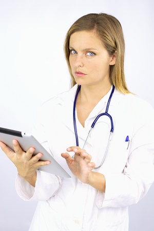Beautiful woman doctor with ipad tablet workingの写真素材