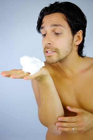 Good looking male model ready to blow shaving cream from his handの写真素材