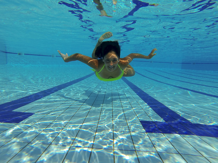 Smiling gorgeous female model underwaterの写真素材