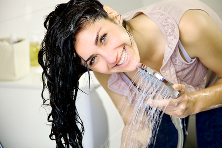 Woman looking camera with wet long hairの写真素材