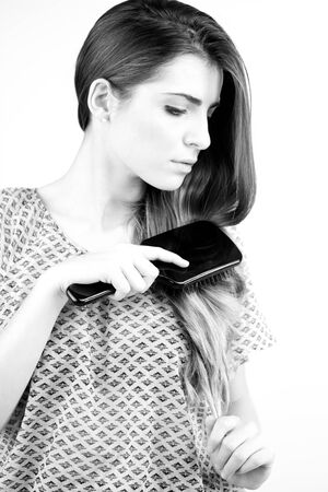 fashion woman brushing her long hair with care. Black and white