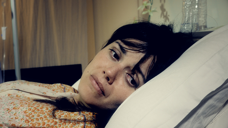 Man holding hand of wife in bed