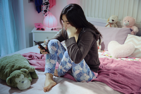 Unhappy sad girl looking phoneの写真素材