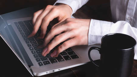 Hands typing on laptop keyboard while fusing - surreal pictureの写真素材