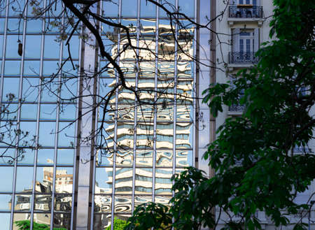 Building reflected in glass window of modern building