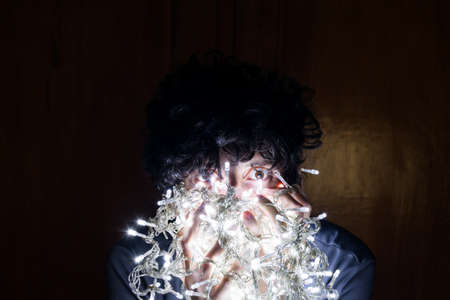 Young man enjoying the Christmas lights in the dark.