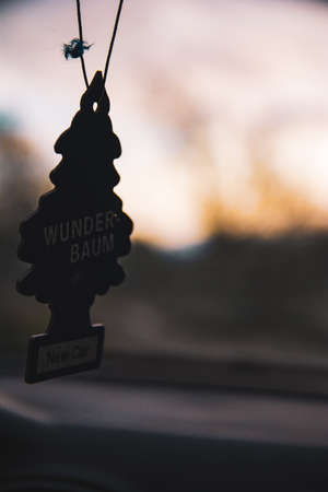Close up of a fragrance tree in a car with the sunset in the background.の写真素材