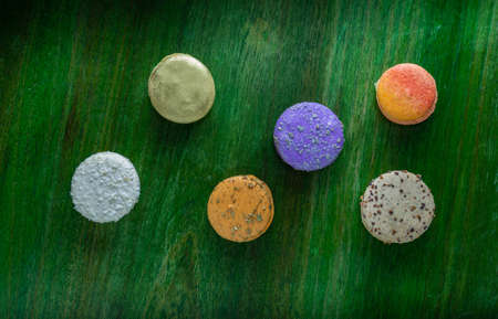 Aerial shot of macaroni of different colors on a wooden table