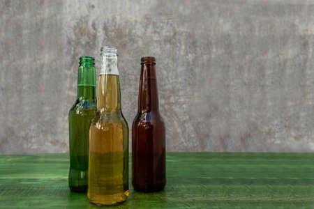 Green, yellow and brown beers on a rustic background on a wooden tableの写真素材