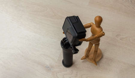 Wooden dummy taking a picture or video with a camera on a tripodの写真素材