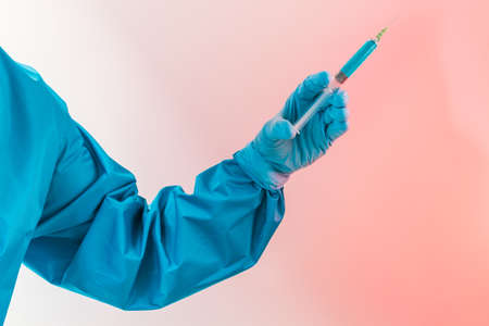 Closeup of an arm holding a syringe with medicine, vaccine