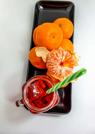 Shot from above of a group of tangerines with ice cream juice, a tangerine is peeledの写真素材