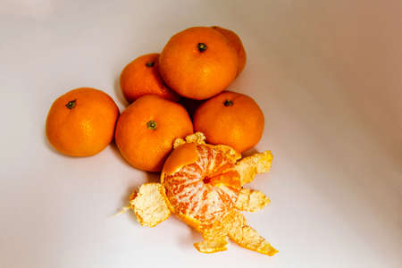 Group of tangerines with one peeled tangerine in frontの写真素材