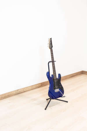 An electric guitar on its shelf placed in a lonely and isolated corner of the houseの写真素材