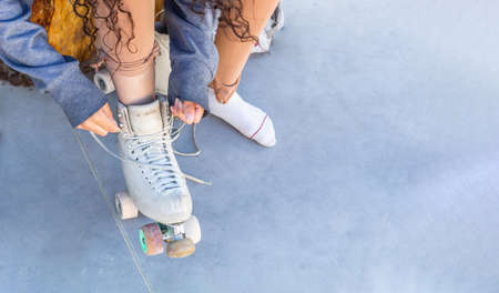 Top view of a girl tying her laces on her skates at a skating rink