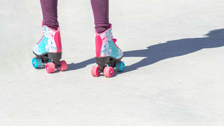 Close-up of colorful roller skates seen from behind on a gray background with good copy space