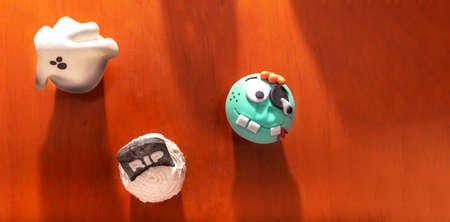 top view of cup cakes with Halloween characters on a wooden background with copyspace. Ghost, tombstone, monster, shadowsの写真素材